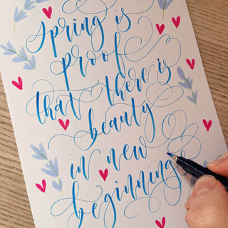 Handwritten quote with decorative elements on a piece of paper.